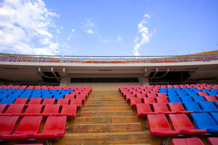 stadium aisle, red  and blue seats on stadium steps isle up bright sky