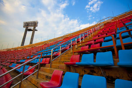 stadium sky, red  and blue seats on stadium steps bleacher with spot light pole up bright skyの写真素材