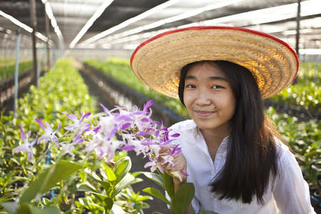 orchid girl, Young Asian girl wearing weave hat in orchid farmの写真素材