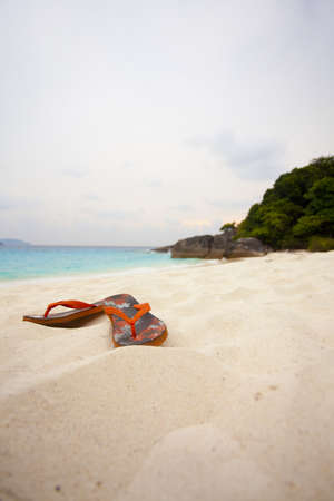 beach sandal, orange sandal on sand beach with sun dawnの写真素材