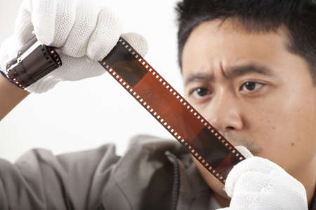 serious film man, male model looking at 35mm filmの写真素材