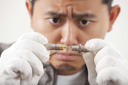 serious repairman, male repairman funny act seriously with PC plug partの写真素材