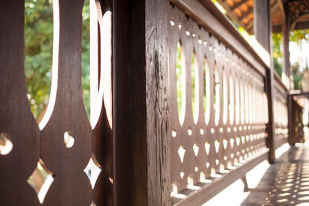 Thai balcony, Antique wood carve Thai style balcony in sun lightingの写真素材