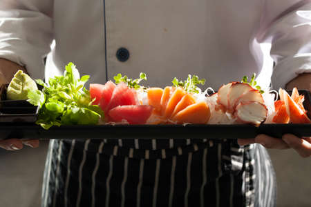 sashimi, Male model in chef uniform holding a dish of Japanese Sashimiの写真素材