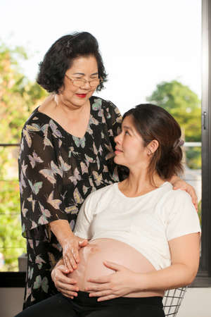 generations Asian Grandmother smile take care of her pregnancy daughterの写真素材