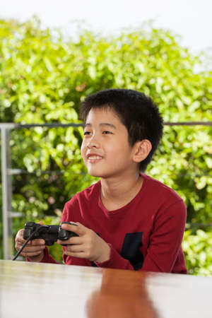 play time an Asian young boy playing with game joystick smiling