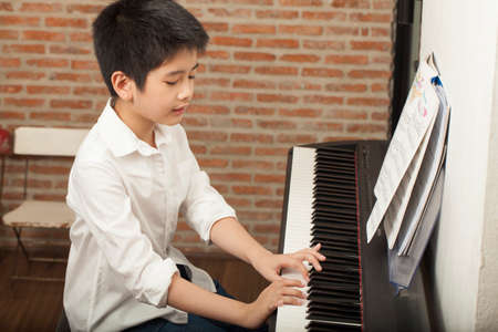piano lesson Asian boy kid activity playing piano with notes smilingの写真素材