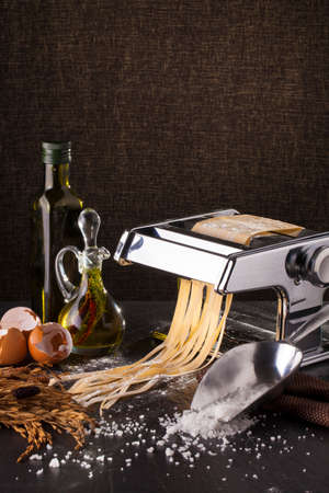 fresh pasta making of homemade fresh pasta tagliatelle with egg and flourの写真素材
