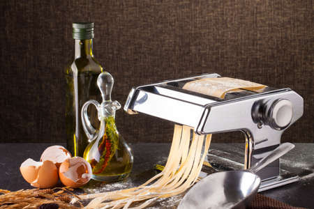 fresh pasta making of homemade fresh pasta tagliatelle with egg and flourの写真素材