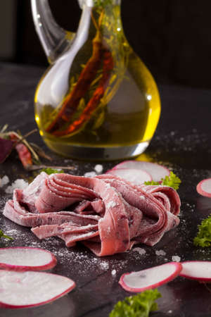 Fresh Pasta Raw beetroot fresh pasta tagliatelle decor with fresh radish on backgroundの写真素材