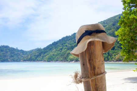 vacation, a lady hat hanging on a log by the nice white sand beach, Thailandの写真素材