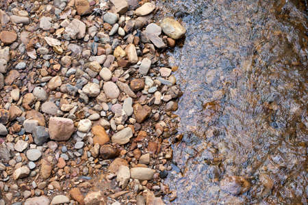 river stone, texture of mixed size of pebbles by the river shoreの写真素材