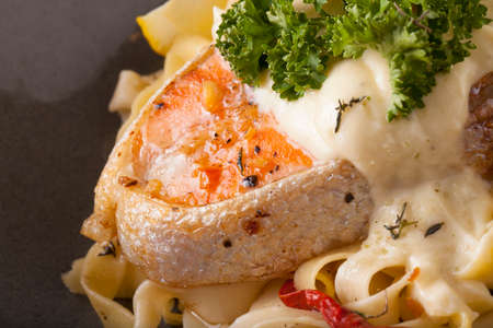Pasta salmon fresh seasoning pasta with grilled salmon steak in a decor dishの写真素材