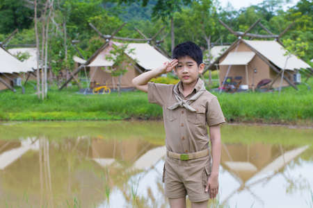 boy scout, a Thai Asian boy scout in uniform with cheerful smile stand at saluteの写真素材