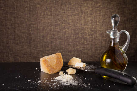grated cheese, grated parmesan cheese with a grater and a jar and bottle of olive  oilの写真素材