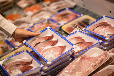 Fresh fish in market, woman hand picking fresh fish in Japanese fresh market, Japanのeditorial素材