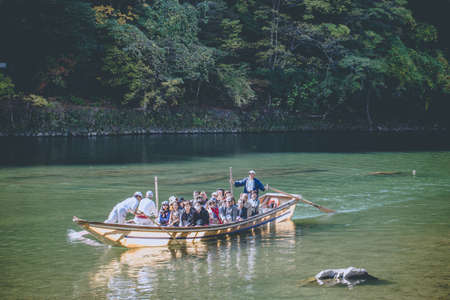 6 Nov 2015, ARASHIYAMA, KYOTO Prefecture, JAPAN, Local boat with a paddler rowing in Katsura green...