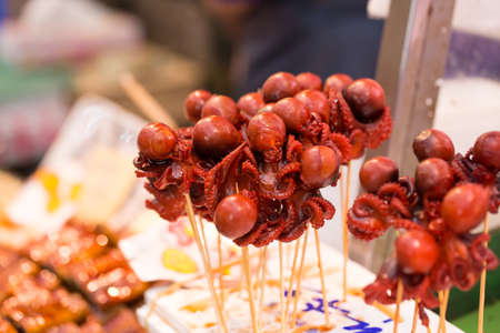 baby octopus stick, red marinated baby octopus in stick selling in fresh market, Japanの写真素材