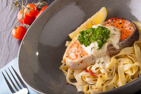 Pasta salmon fresh seasoning pasta with grilled salmon steak in a decor dishの写真素材