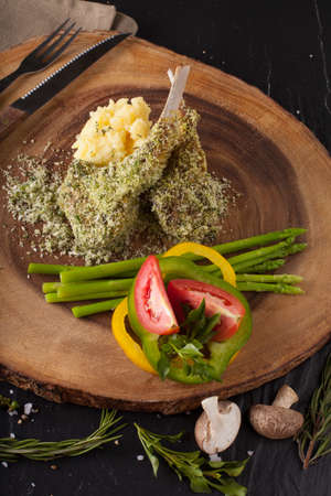 Rack of lamb steak cut in pieces seasoning with crusted mint vegetable and herbs and red wine serve on chopping wood blockの写真素材