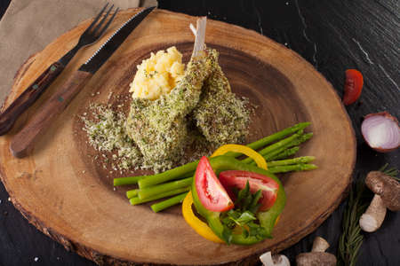 Rack of lamb steak cut in pieces seasoning with crusted mint vegetable and herbs and red wine serve on chopping wood blockの写真素材