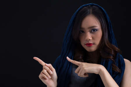 Mysterious girl presenting blank right side  empty copy space wearing red lipstick with blue fabric cover her head beauty shotの写真素材