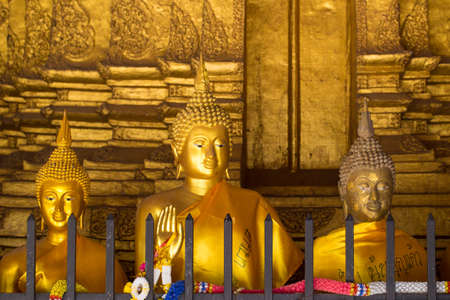 Golden Buddha statue head close up with sun light and shadowの写真素材