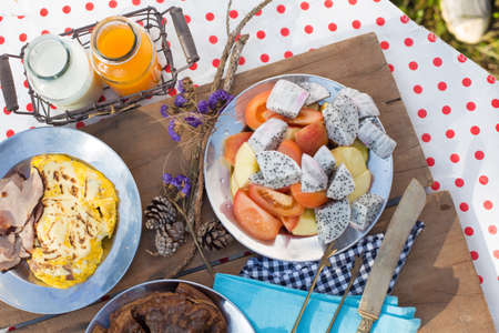 Various breakfast table with fruits egg and sausage, orange juice and milkの写真素材