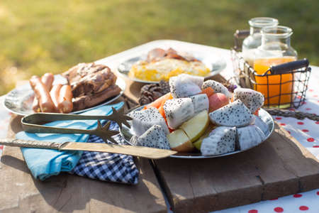 Various breakfast table with fruits egg and sausage, orange juice and milkの写真素材