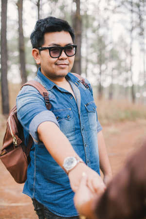 A man with his couple hold hands traveling in pine forest, Thailandの写真素材