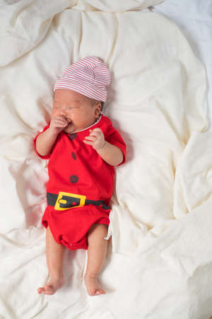 Asian baby boy wearing red Santa Claus outfit.の写真素材