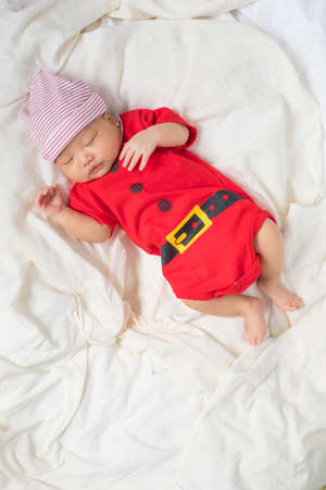 Asian baby boy wearing red Santa Claus outfit with reindeer hat.の写真素材