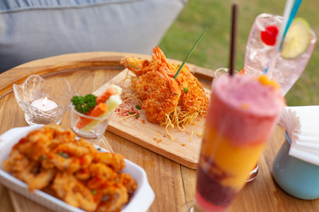 Close up to appetizer calamari and fried shrimp on tray with colourful smoothy.の写真素材