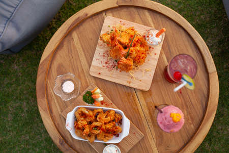 Close up to appetizer calamari and fried shrimp on tray with colourful smoothy.の写真素材
