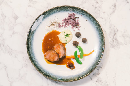 Top view of salmon fillet with sauce and vegetables on white marble table