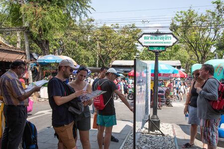 BANGKOK, THAILAND - February 23, 2019 : Tourist couple use their map to determine direction and point in the way they wish to go at Chatuchak weekend market.のeditorial素材