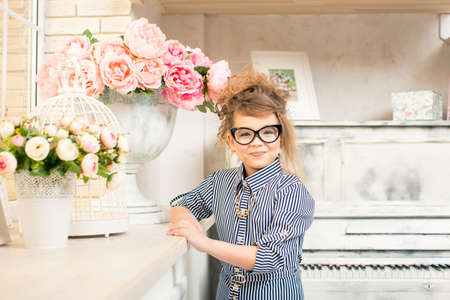 beautiful girl with flowers at the pianoの写真素材