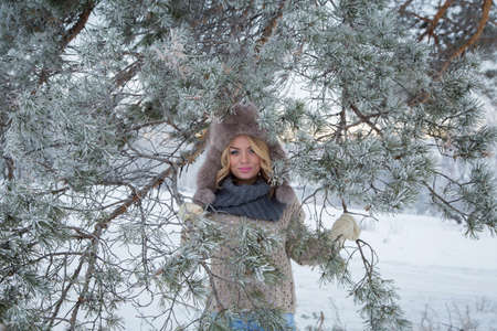 Winter portrait of beautiful smiling woman with snowflakes in white furs snowの写真素材