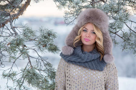 Winter portrait of beautiful smiling woman with snowflakes in white furs snowの写真素材