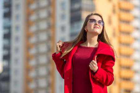 beautiful girl in a red coat and glassesの写真素材