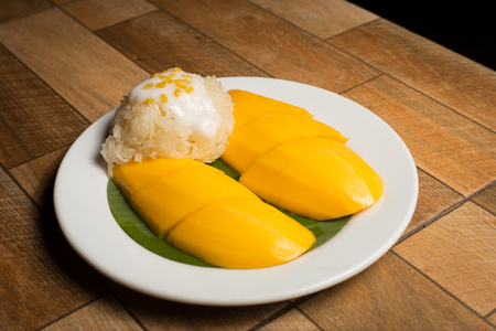 Mango and sticky rice in the white dish on wooden floor,Thai dessert popular in the summer of Thailandの写真素材