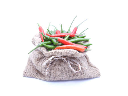Red and green chilli and brown sack on White isolatedの写真素材