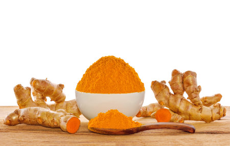 Turmeric roots with turmeric powder on white background