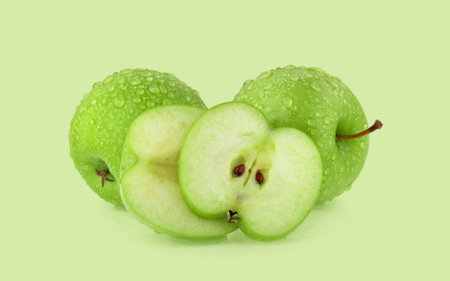 green apple with drop of water isolated on green background.の写真素材