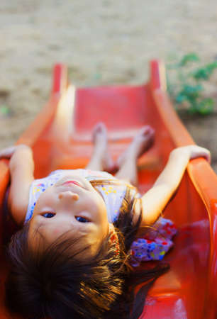 Kid playing on the slide on playground at thailandの素材