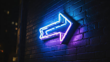A vibrant neon arrow sign illuminated in blue and purple hues is mounted on a dark brick wall. The arrow points to the right, adding a dynamic visual element to the urban setting. The background is dimly lit, highlighting the vivid colors of the neon sign.の素材