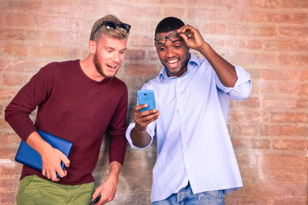 Surprised face friends looking phone screen - Afro american and caucasian students astonished facial...