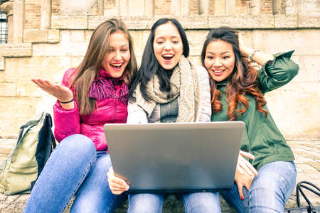 Girls looking at pc surprised - Young women having fun with laptop outdoor at winter holidays - Female friends shocked by cheap prices of shopping on line - Concept of internet modern sales channelsの写真素材
