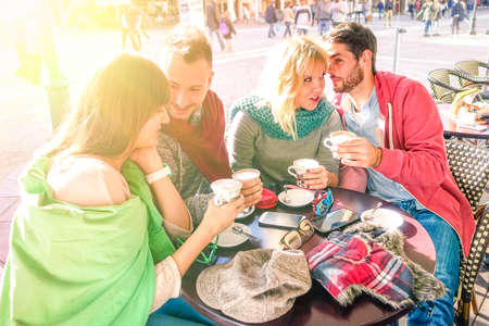 Group of best friends drinking cappuccino at bar cafe restaurant - Teenagers talking and sharing happy moments together around table - Concept of friendship and relations - Sun halo filterの写真素材
