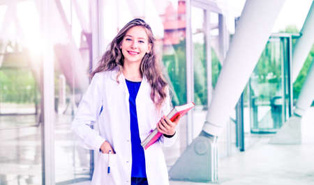 Young woman dentist student standing with positive attitude smiling at camera - Beautiful female doctor scientist looking happy and professionalの写真素材